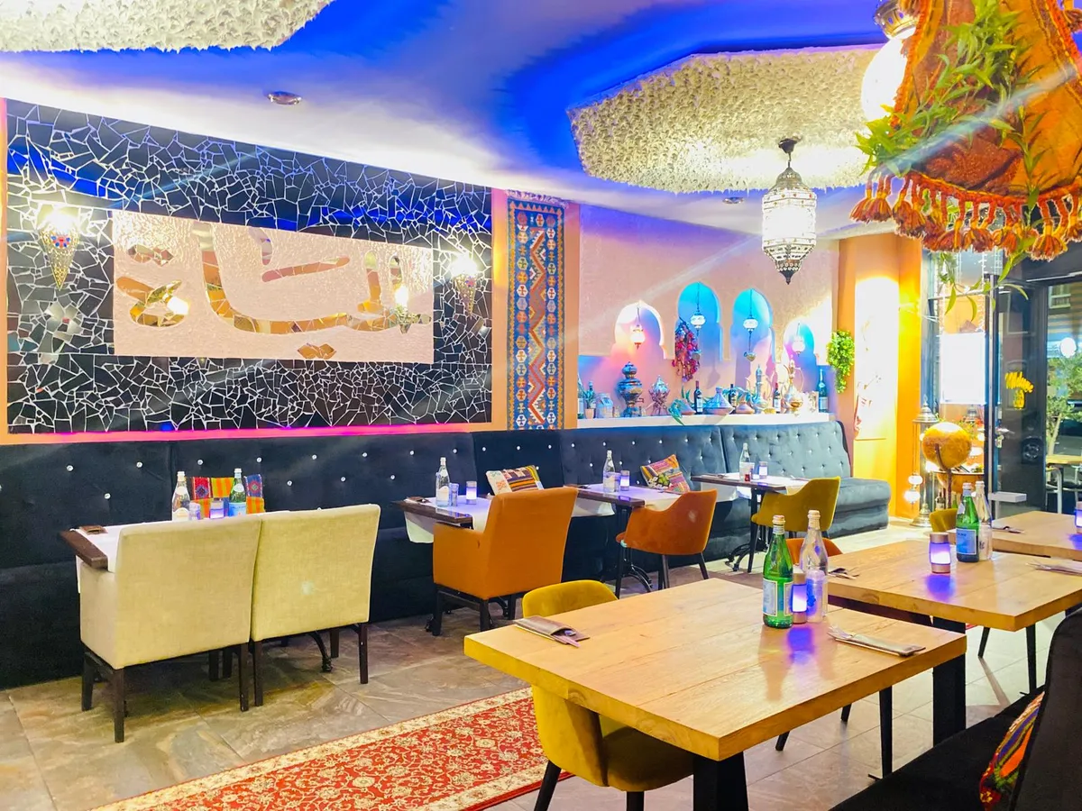 Onze eetzaal met warme oranje wanden en Arabische kalligrafie