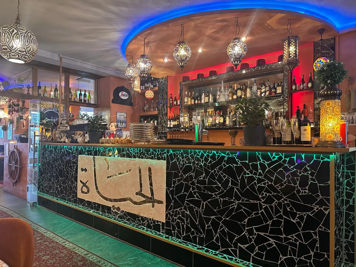 De mozaïekbar met de الحياة-kalligrafie in het tegelwerk