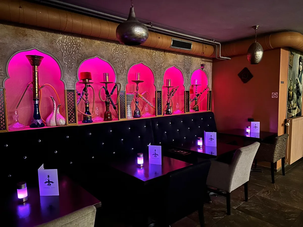 De roze verlichte shisha-lounge met knusse alkoven